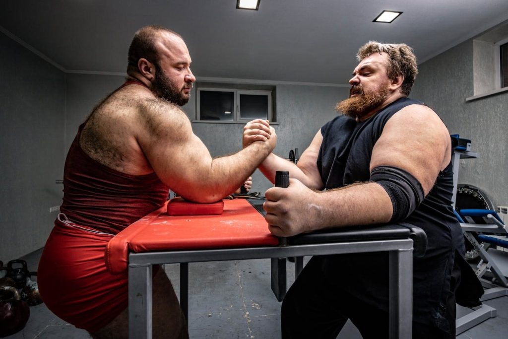 two buff men armwrestling to show the roughly even matchup between sdn bhd vs llp